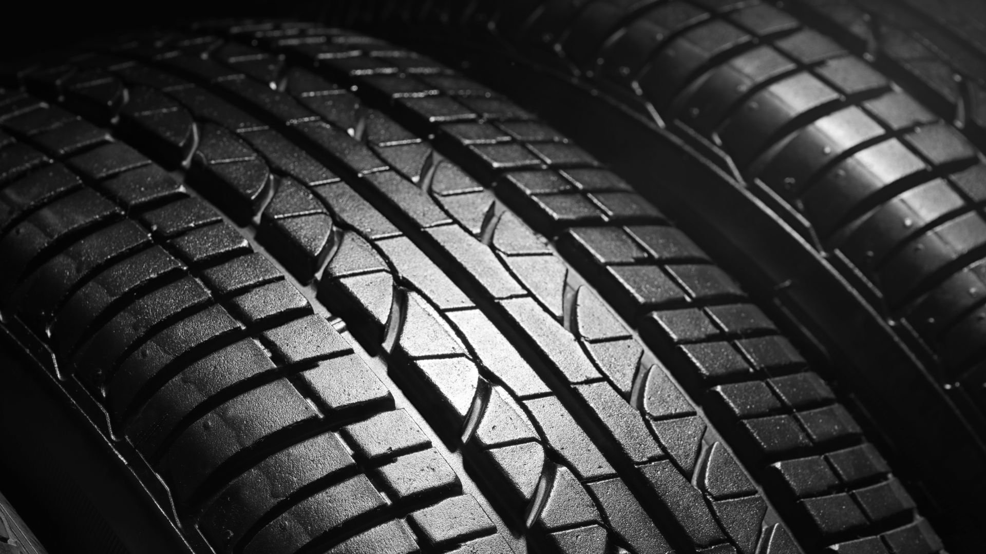 Close-up of black and white car tire treads with detailed texture