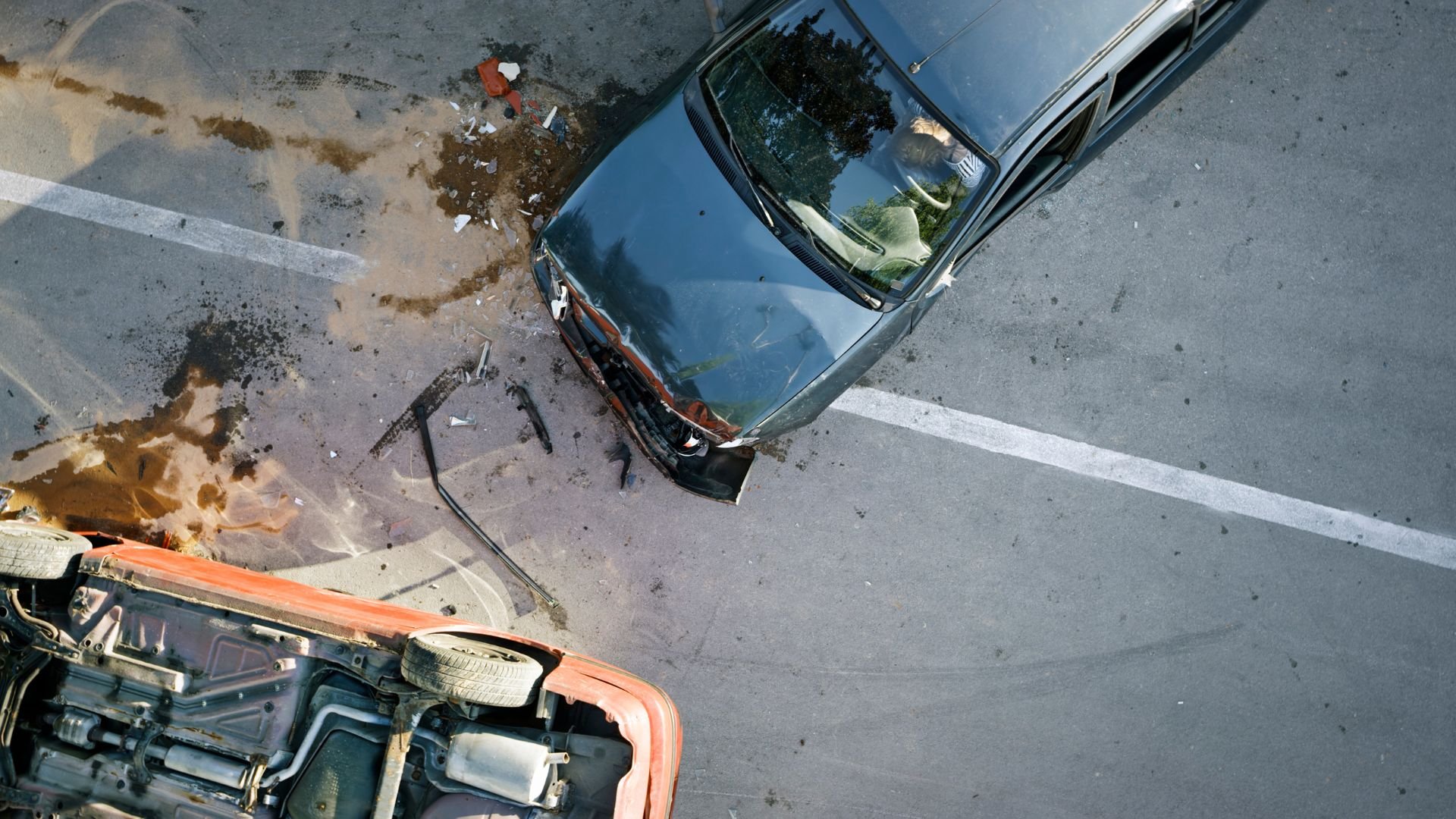 Overhead view of two cars in a severe collision on a road